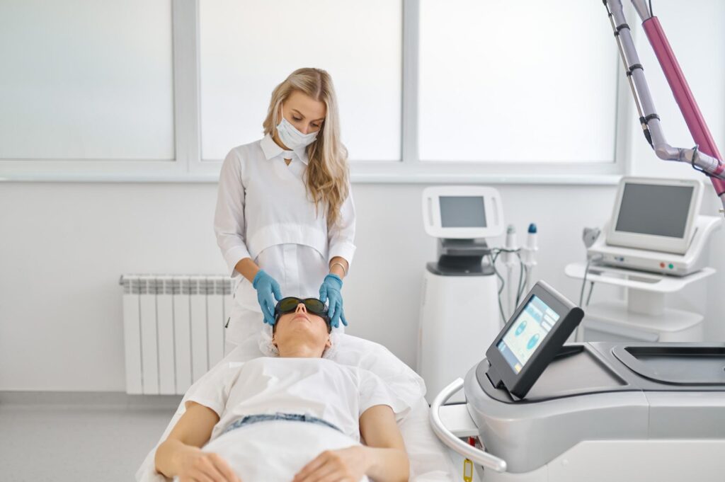 A woman is getting a laser treatment in a medical room.