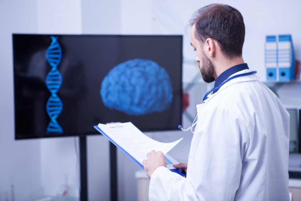 A doctor looking at a dna image on a tv.