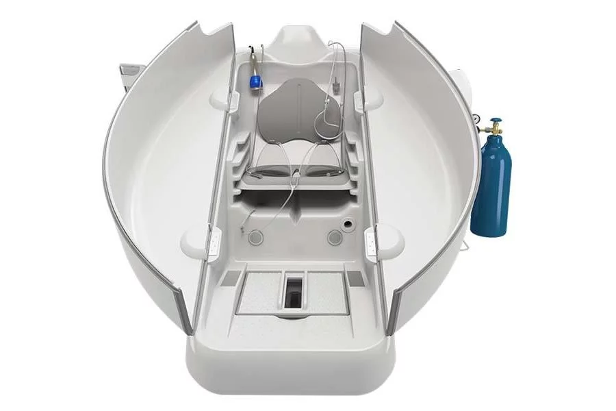 An open ozone sauna chamber showing its interior seating and tubing, with a blue oxygen cylinder beside it.